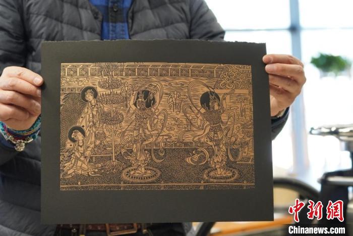 圖為手工書(shū)藝人展示敦煌雕版壁畫(huà)印刷品?！【琶赖┰?　攝