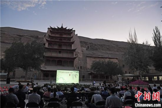 2018年8月，在敦煌莫高窟標(biāo)志性建筑“九層樓”前，《回顧平山郁夫先生的貢獻(xiàn)》座談會(huì)舉行。來自中日兩國的專家、學(xué)者共同懷念這位情系敦煌數(shù)十載的繪畫巨匠、中日友好的文化使者、世界文化遺產(chǎn)的守護(hù)者。中新社記者 楊艷敏 攝