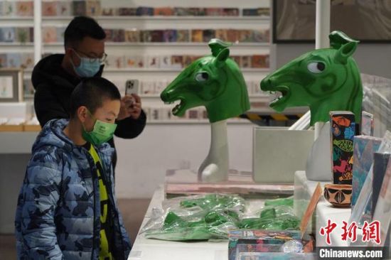 圖為“神馬來(lái)了”銅奔馬頭套吸引參觀者駐足。　九美旦增 攝