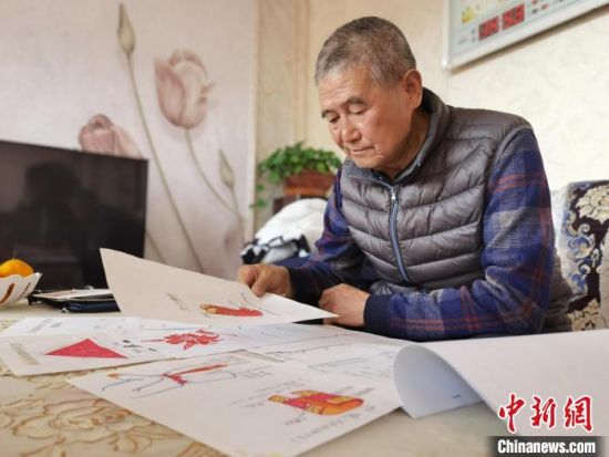 圖為陸鵬飛向記者展示多年帶隊(duì)的手寫筆記?！堟?攝