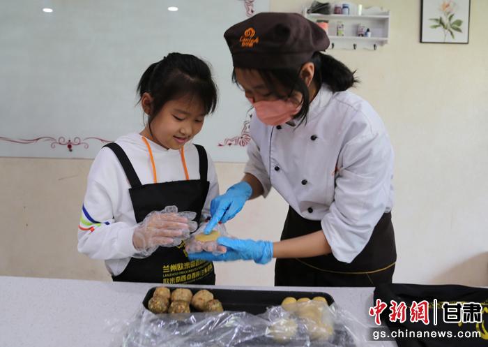 圖為在甘臺胞小朋友在工作人員指導下制作月餅。九美旦增 攝