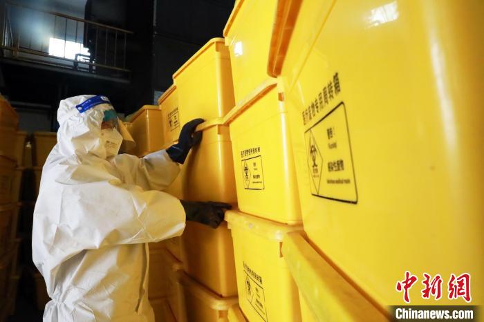 圖為工作人員搬運醫(yī)療廢物專用周轉箱。　魏建軍 攝