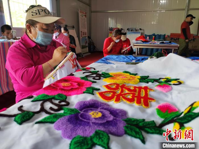 圖為婦女制作青繡?！?zhí)砀?攝
