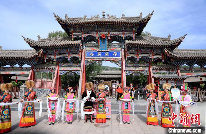 圖為身穿土族服飾的工作人員迎接訪客?！⊙Φ?攝