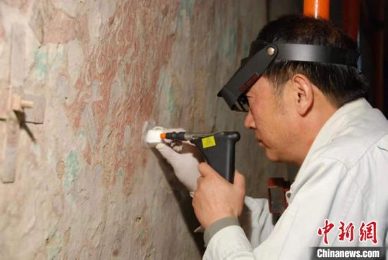 敦煌研究院研究員樊再軒進(jìn)行壁畫(huà)修復(fù)。(資料圖)張?jiān)莆?攝