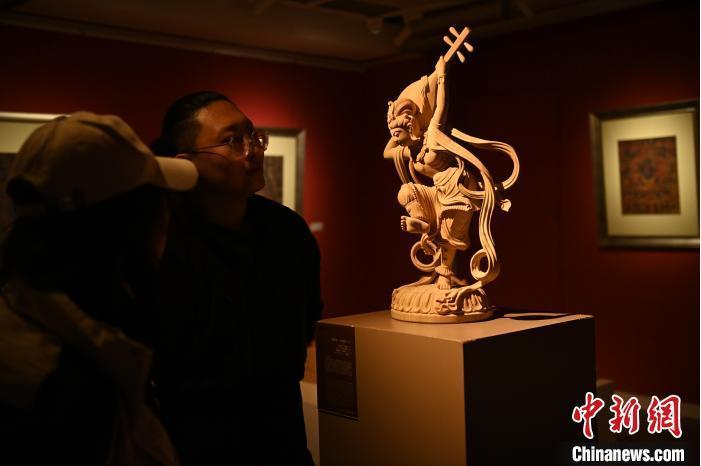 圖為季茂杰向參觀者介紹自己創(chuàng)作敦煌木雕的過程。李亞龍 攝</p>
<p>