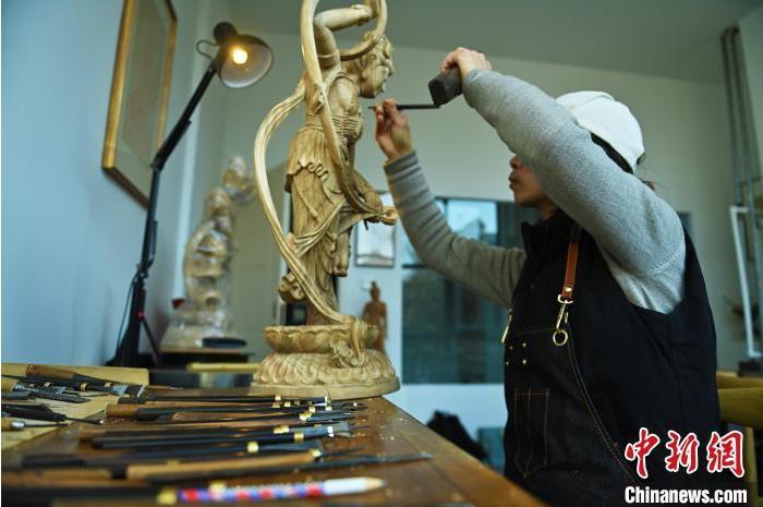 圖為季茂杰進行敦煌元素的木雕創(chuàng)作。李亞龍 攝</p>
<p>