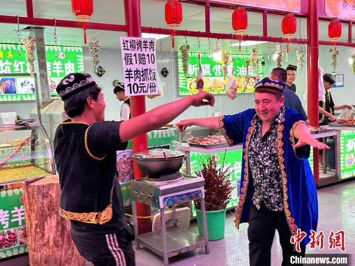 圖為餐飲經(jīng)營者在“西涼不夜城”跳起舞蹈引客?！〈魑牟?攝</p><p>