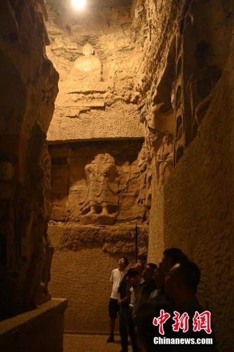 7月15日，游人參觀甘肅省平?jīng)鍪袥艽h百里石窟長廊中的王母宮石窟。百里石窟長廊位于涇川縣境內(nèi)，由512個石窟、5眼窟中石井組成，現(xiàn)存王母宮石窟、鳳凰山石窟、南石窟寺、丈八寺石窟、羅漢洞石窟、太山寺石窟等規(guī)模較大的石窟群，還有數(shù)量眾多的小石窟群。王母宮石窟又名千佛洞，該窟設(shè)計宏大，造像生動，窟內(nèi)擁有造像數(shù)百尊，是較為珍貴的佛教文化遺存。中新社記者 李亞龍 攝</p>
<p>