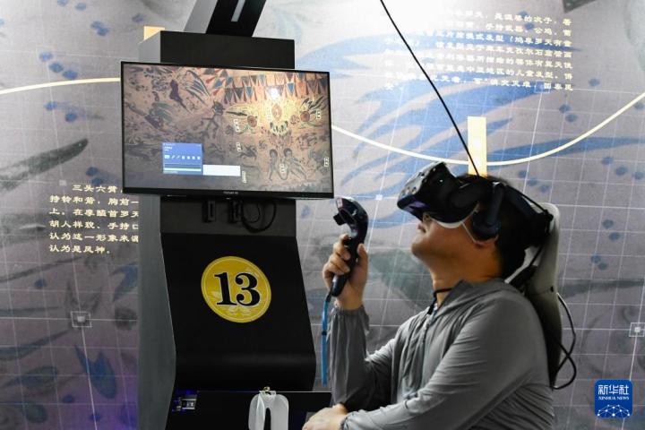 7月22日，游客借助VR設(shè)備沉浸式游覽莫高窟第285窟虛擬場景。新華社記者 郎兵兵 攝